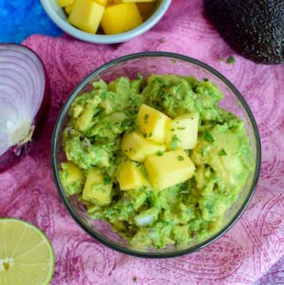 Homemade guacamole is the best! But, to make it even better - top with freshly chopped mango to make a mango guacamole to enjoy alone with chips or on tacos!